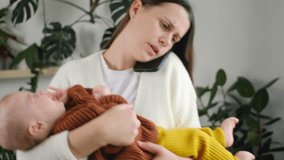 Worried young mother holding newborn baby son on hands and talking on smartphone, concerned sad millennial mom calling to doctor to get advice about infant health and child care. Motherhood concept - Powered by Shutterstock - Get 15% off with code: PIKWIZARD15