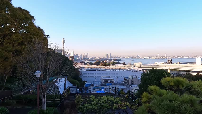 Panoramic view over Cityscape of Minatomirai, Yokohama, Kanagawa Prefecture, Japan. calm evening light blue sky soft blue water. Indstrial port area with yokohama Bay Bridge