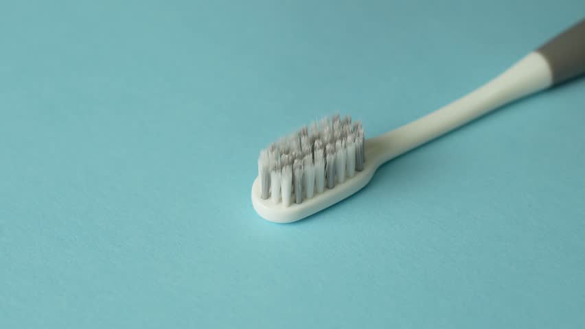 Close-up view of toothpaste with toothbrush. Applying toothpaste on a toothbrush for brushing teeth. Dental health care and oral hygiene, 4k slow motion
