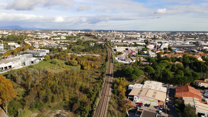 Aerial shot of Montpellier with urban structures, greenery, and railway.