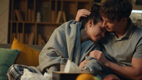 Caring man hugging unhealthy girlfriend sitting home couch together close up. Young husband supporting sick wife suffering from flu drinking water. Loving boyfriend taking care of ill exhausted woman. - Powered by Shutterstock - Get 15% off with code: PIKWIZARD15