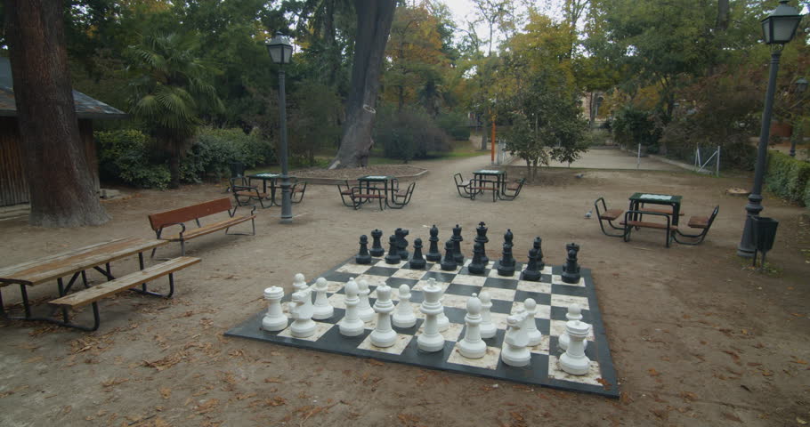 Giant chessboard in the middle of a park in Madrid. No people. Wide-shot.