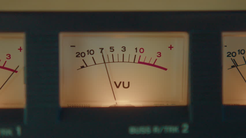 Analog volume unit meter on cassette deck, arrow moving synchronically to music and showing level of sound. Close-up view, zoom shot