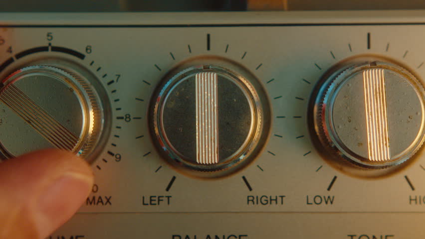 Hand turning Volume, Balance and Tone knobs on retro boombox, adjusting sound while playing music. Close-up view, zoom-out shot Royalty-Free Stock Footage #1110249427