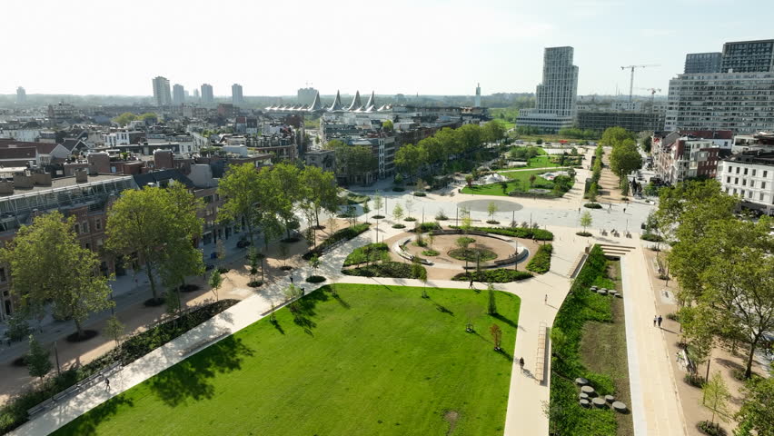 Aerial flight over grass field and Zuid park in Antwerp Cityscape during sunny day, Belgium