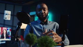 Close up of smartphone on holder and mic used by online star in dimly lit home studio to film video for online platforms. Phone being used by influencer to record footage, hip level shot - Powered by Shutterstock - Get 15% off with code: PIKWIZARD15