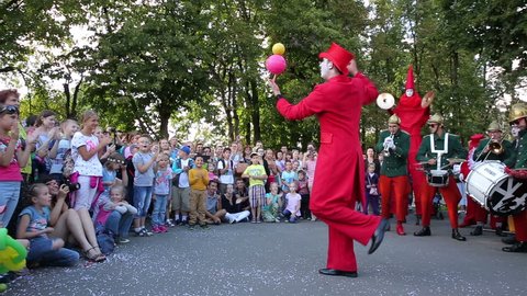MOSCOW, RUSSIA - JULY 31, 2015: Clown juggler performs in front of children. Show of street performers circus "Stupid Circus High Brothers". Festival of street theatres "Inspiration".