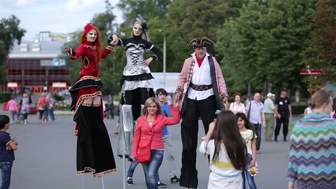 MOSCOW, RUSSIA - JULY 31, 2015: Show street circus performers on stilts. Pedestrians photographed with actors on stilts. Festival of street theaters "Inspiration".