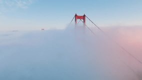 Aerial video of the Golden Gate Bridge. Inspirational drone flight around red tower above epic ocean of pink clouds covering San Francisco Bay until horizon. Breathtaking background California USA 4K