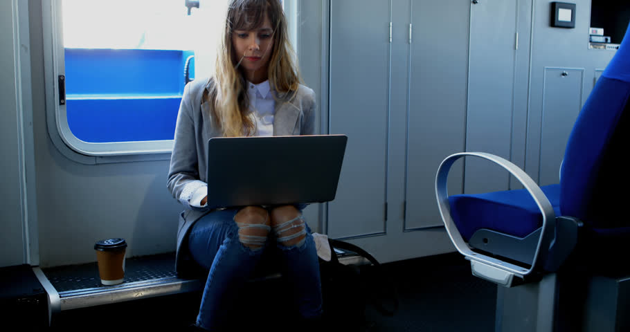Animation of message box over caucasian woman working on laptop and drinking coffee in train. Digital composite, multiple exposure, beverage, transportation, drink and technology concept.