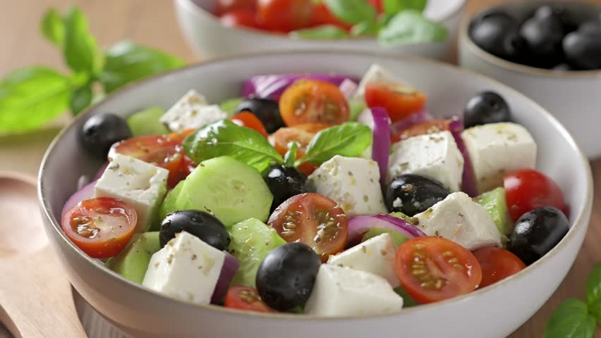 Eating traditional Greek salad. Fresh vegetable salad with feta cheese.