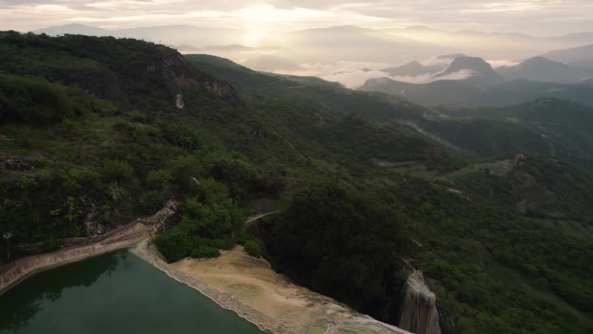 Drone beautiful view of Hierve el Agua rocky cliff with forest mountains in Mexico