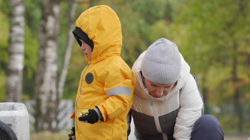 mother and toddler child little boy in autumn city park. Pavlovsk, St. Petersburg, Russia.