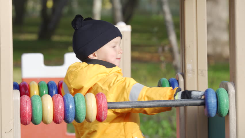 toddler child little boy playing on children playground in autumn city park