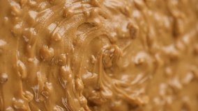 Crunchy peanut butter with pieces of peanuts, rotation. Vertical video