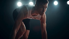 Strong Young Man Starting a Race From Track Starting Blocks Position on a Dark Stadium in the Evening. Cinematic Portrait of a Fit Male Sprint Runner Participating in a Competition - Powered by Shutterstock - Get 15% off with code: PIKWIZARD15