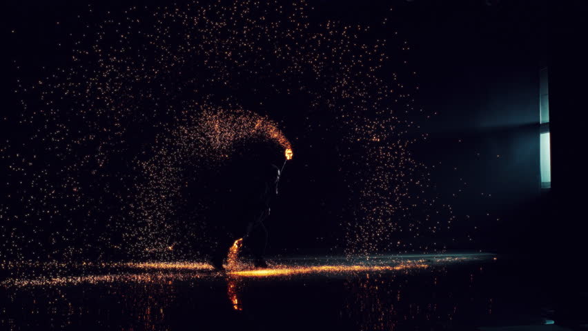 Silhouette of a Fire Artist Spinning Fire Poi in a Dark Space. Bright Hot Sparks Flying Around Across the Room. Cinematic Super Slow Motion Footage with Dramatic Speed Ramp Effect Royalty-Free Stock Footage #1110269979