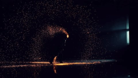Silhouette of a Fire Artist Spinning Fire Poi in a Dark Space. Bright Hot Sparks Flying Around Across the Room. Cinematic Super Slow Motion Footage with Dramatic Speed Ramp Effect Adlı Stok Video