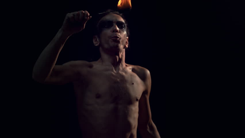 Fire Breather Performing at a Show on a Dark Stage. Male Performer Blowing Fire Out of His Mouth with a Striking Visual Effect. Cinematic Super Slow Motion Footage at 1000fps
