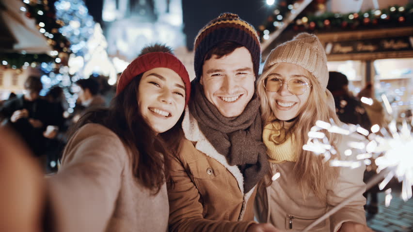 POV Two women and man smiling waving firework take selfie outdoor. Christmas holiday. Multiracial group of friends having fun with sparklers outdoor celebrating merry Christmas xmas and happy new year Royalty-Free Stock Footage #1110279469