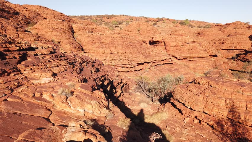 Edge of Kings Canyon with tall walls, red sandstone and bush vegetation. Canyon of Australia Outback Red Center in Northern Territory.