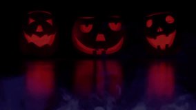 pumpkins under scary full moon cinematic loop video animation background.Glowing pumpkin lantern on wooden table in Halloween 31st October