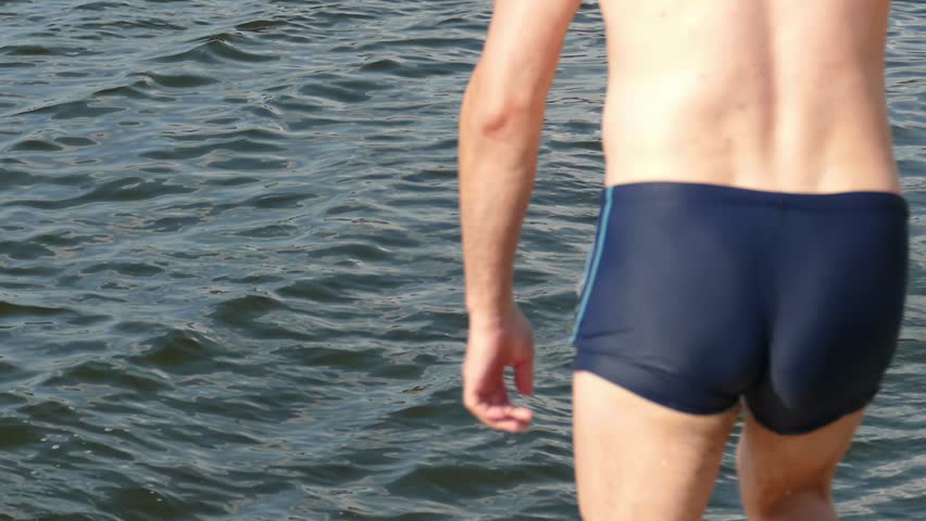 Jumping into the water in slow motion. Summer fun. A guy jumps into the water from a pier. Big splashes.