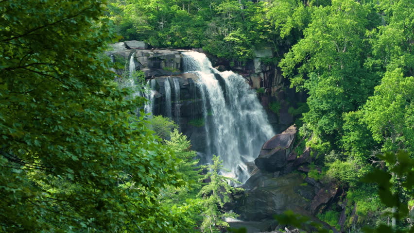 Aerial view of Whitewater Falls in Nantahala National Forest, North Carolina, USA. Clear water falling down from rocky boulders between green lush woods