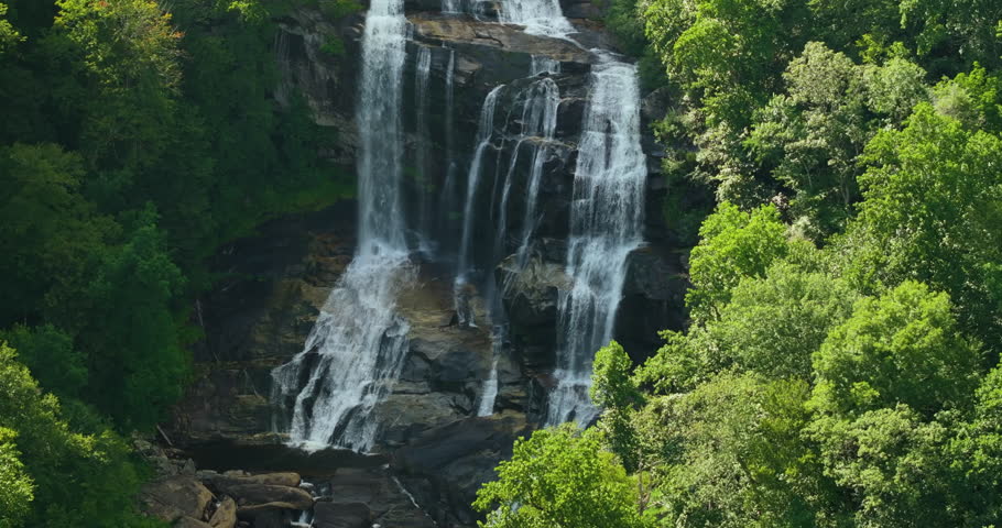 Aerial view of Whitewater Falls in Nantahala National Forest, North Carolina, USA. Clear water falling down from rocky boulders between green lush woods