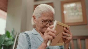 Happy Asian elderly older grandmother holding family photographs on hands and hugging while missing moments and memory of life. Elderly older lifestyle concept - Powered by Shutterstock - Get 15% off with code: PIKWIZARD15