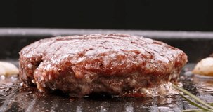 Beef cutlet for halal burger fried in frying pan. Cinematic advertisement burger cooking. Cutlet is turned over to cook on other side. Crispy, golden, oh-so-satisfying. Pan-fried cutlets mouthwatering
