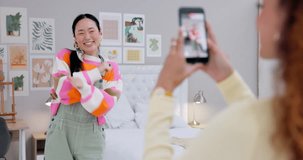 Asian woman streaming, dancing with phone and friends post for content creation, happiness and fun. Smile, energy and music, influencer with viral video for social media challenge with smartphone.