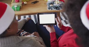 African american mother and adult daughter on tablet christmas video call, copy space, slow motion. Christmas, communication, family, togetherness and celebration.