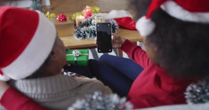 African american mother and adult daughter on smartphone xmas video call, copy space, slow motion. Christmas, communication, family, togetherness and celebration.