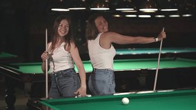 two women are dancing. two women and billiards. women in white T-shirts. slow motion video. Record high quality video in Full HD format.