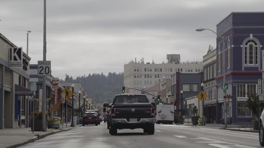 Skateboarder and cars on street in small town  astoria, oregon, united states