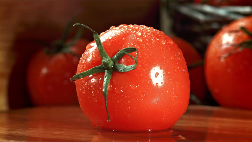 A knife cuts a tomato with splashes. Filmed on a high-speed camera at 1000 fps. High quality FullHD footage