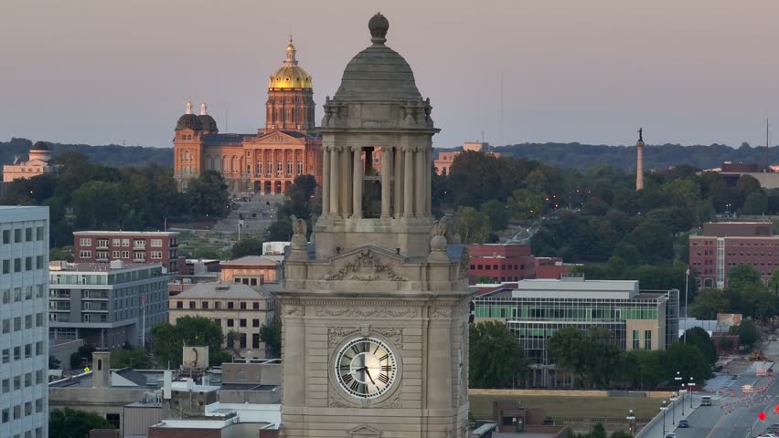 Des Moines, Iowa skyline with iconic golden Capitol dome and historic Polk County Courthouse. Aerial parallax view of urban cityscape at dusk.