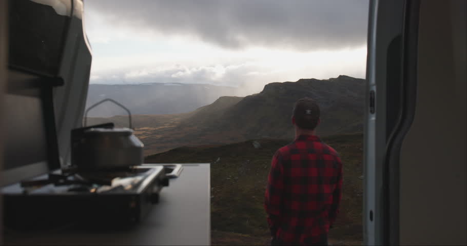 Back of male by campervan kitchen stove admire Jotunheimen mountain sunset view Royalty-Free Stock Footage #1110330273
