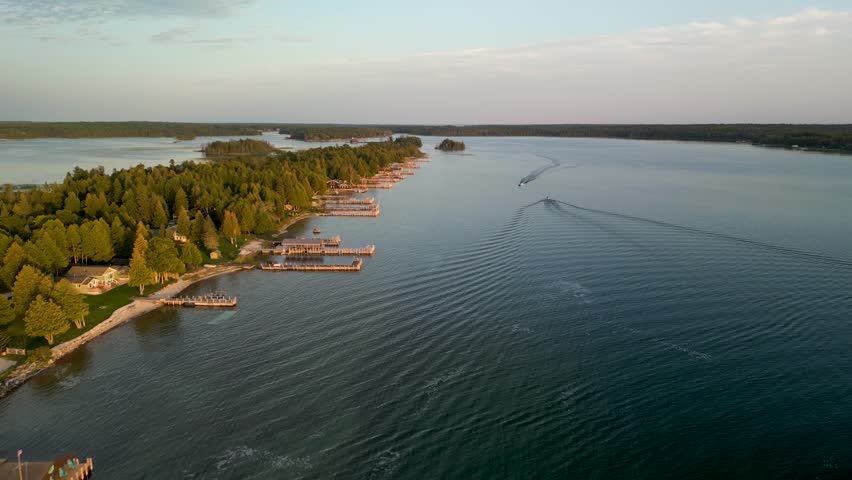 Aerial ascending view of boats on water and coastline golden hour, Les Cheneaux Islands, Michigan