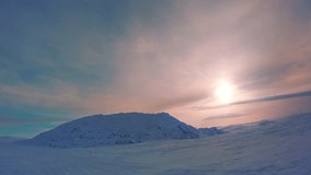 Scenic video - snow mobile drive fast to Swedish Mountain range Atoklimpen (Atoklinten). Large low Sun in frosty cold foggy winter sky, beautiful evening light, blue shadows