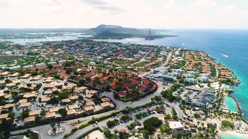 Beautiful coastal neighborhood of Jan Thiel, drone tilts down over Zanzibar beach Curacao