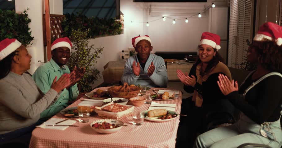 African family having fun eating and singing songs together during Christmas time while wearing santa claus hat - Holiday concept Royalty-Free Stock Footage #1110340723
