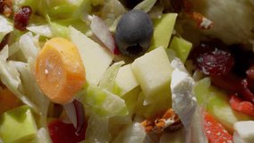 Delicious fresh nutritious healthy greek diet salad in a bowl on a sunny table, 4K smooth video of exotic spring appetizer with tomato, salad, carrot, apple, cranberry, cheese vegetables