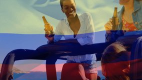 Composite video of waving colombia flag over two diverse girls drinking beers and talking in the car. Patriotism, road trip and camping concept