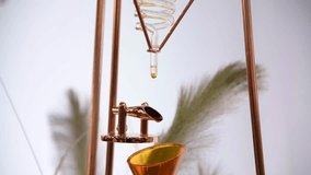 Close-up view of making Cold Brew Coffee drink by beautiful glass dripper with helix and funnel. Soft focus. Real time handheld video. Alternative coffee preparing theme.