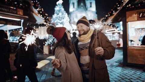 Mix race couple having fun with sparklers outdoor celebrating merry Christmas xmas happy new year. Young man and woman on date in love smiling waving firework express joy happiness. Christmas holiday ஸ்டாக் வீடியோ