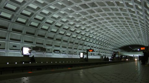 WASHINGTON, DC - APRIL 2013: DC Metro subway trains arrives opposite platform, commuters exit, at busy Ballston station in suburban Arlington, Virginia.