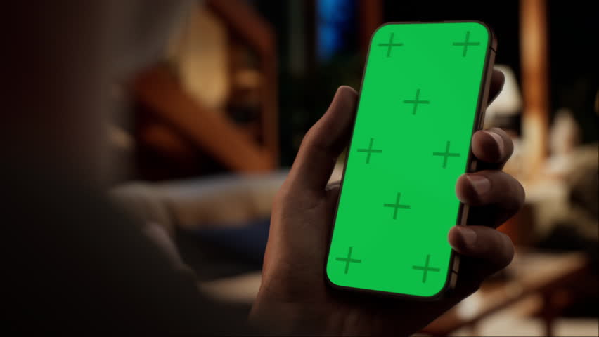 CU Green screen chroma key, Black African-American man using his phone at home. Evening shot, furnished house interior in the background - Powered by Shutterstock - Get 15% off with code: PIKWIZARD15