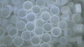 Empty white plastic bottles caps bottles Manual clean machine washed clean at plastic caps factory. Environmental waste and recycling concept - Powered by Shutterstock - Get 15% off with code: PIKWIZARD15